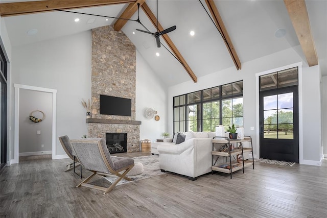 18569 310th St, Norman, OK 73072 - living room with high vaulted ceiling, beamed ceiling, a ceiling fan, wood finished floors, and a stone fireplace