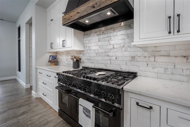 18569 310th St, Norman, OK 73072 - kitchen featuring range with two ovens, exhaust hood, tasteful backsplash, white cabinets, and wood finished floors