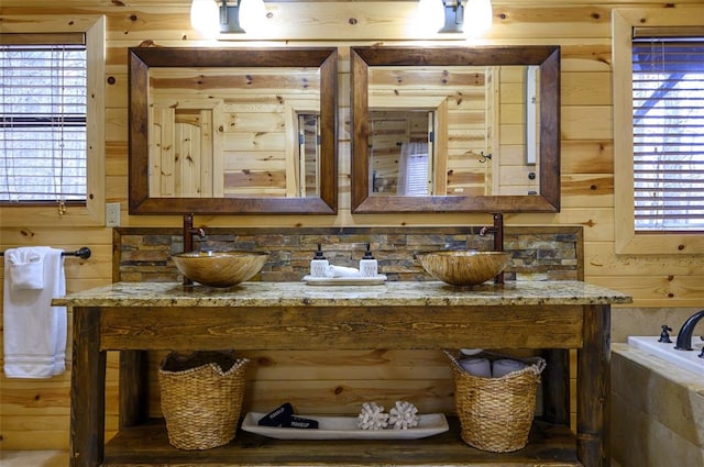 225 Stevens Rd, Broken Bow, OK 74728 - bathroom featuring double vanity, wooden walls, plenty of natural light, and a tub to relax in