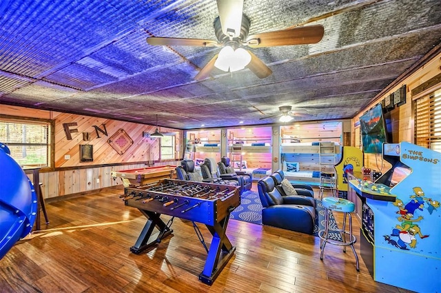 225 Stevens Rd, Broken Bow, OK 74728 - recreation room with ceiling fan, wood walls, healthy amount of natural light, and hardwood / wood-style floors