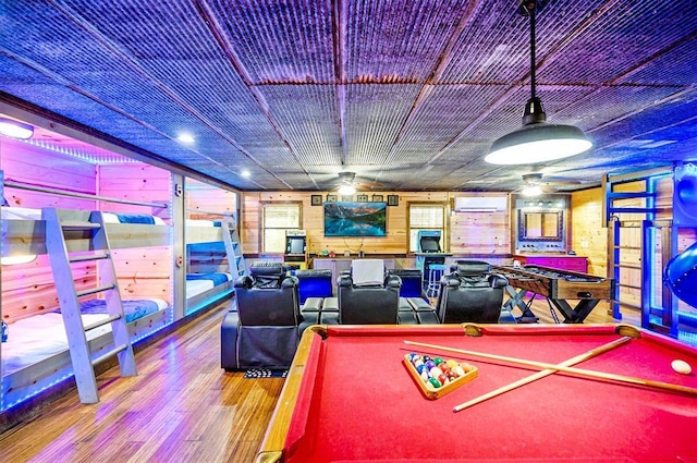 225 Stevens Rd, Broken Bow, OK 74728 - recreation room with billiards table, a wall unit AC, wood finished floors, a ceiling fan, and wood walls