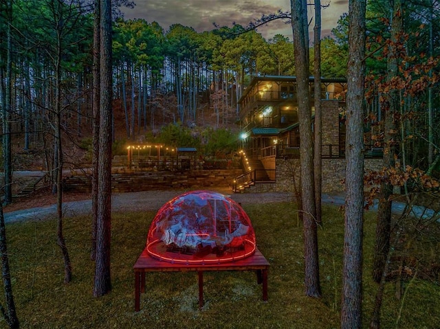 225 Stevens Rd, Broken Bow, OK 74728 - yard at dusk featuring a yard and a wooded view