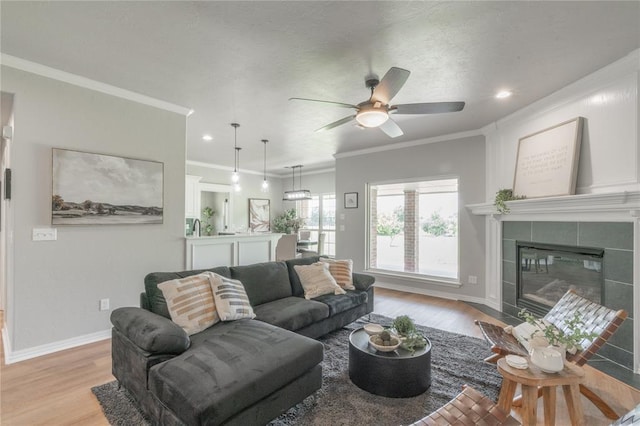 1848 County Road 1198, Tuttle, OK 73089 - living area featuring light wood-style flooring, ornamental molding, ceiling fan, a fireplace, and recessed lighting