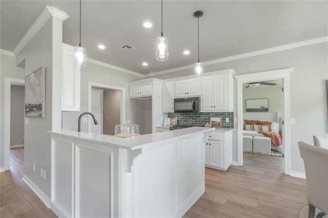 1848 County Road 1198, Tuttle, OK 73089 - kitchen with black microwave, recessed lighting, light wood finished floors, tasteful backsplash, and crown molding