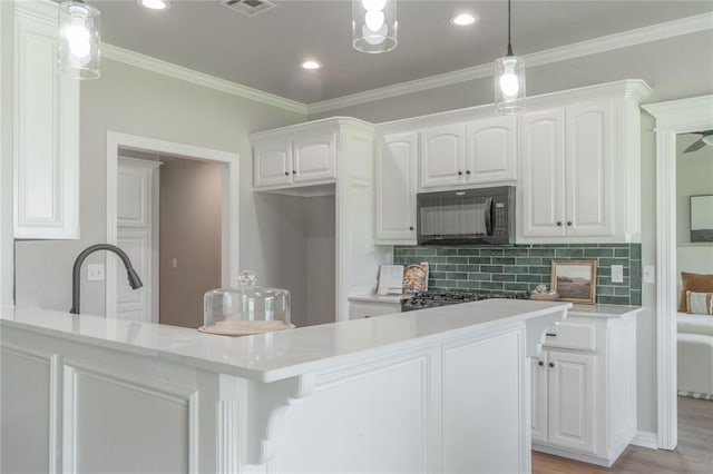 1848 County Road 1198, Tuttle, OK 73089 - kitchen featuring black microwave, white cabinetry, decorative backsplash, light countertops, and ornamental molding