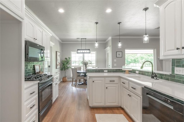 1848 County Road 1198, Tuttle, OK 73089 - kitchen with black appliances, healthy amount of natural light, white cabinetry, a peninsula, and recessed lighting