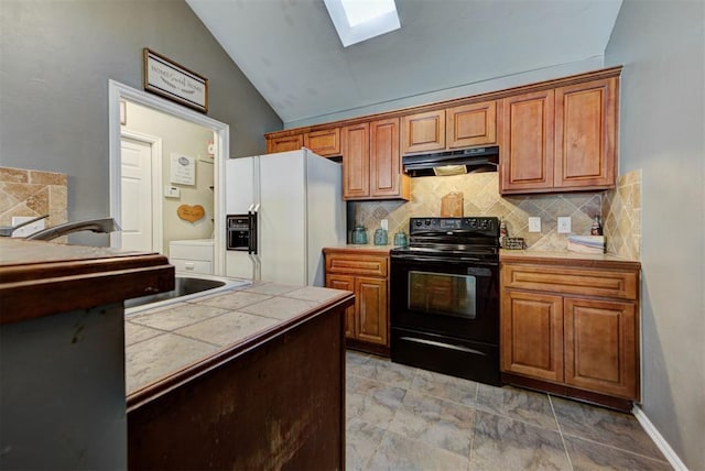 2233 NW 196th St, Edmond, OK 73012 - kitchen with white refrigerator with ice dispenser, black range with electric cooktop, under cabinet range hood, lofted ceiling, and tasteful backsplash