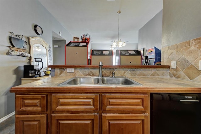2233 NW 196th St, Edmond, OK 73012 - kitchen with black dishwasher, brown cabinetry, a chandelier, tasteful backsplash, and a peninsula