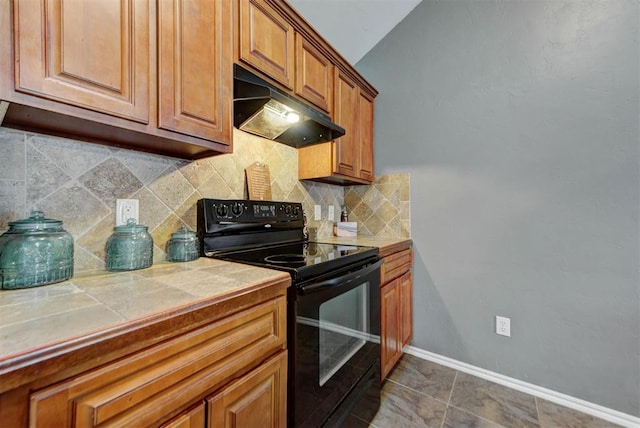 2233 NW 196th St, Edmond, OK 73012 - kitchen featuring black range with electric cooktop, under cabinet range hood, tile countertops, backsplash, and brown cabinets