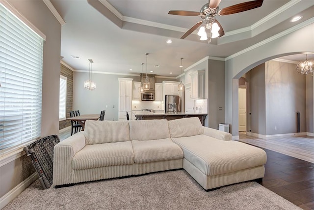 4600 Kentucky Ridge Dr, Mustang, OK 73064 - living area with a chandelier, arched walkways, a tray ceiling, light wood finished floors, and recessed lighting