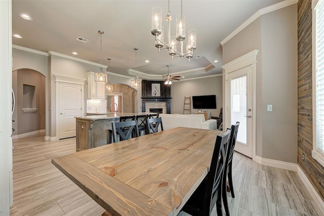 4600 Kentucky Ridge Dr, Mustang, OK 73064 - dining space with ceiling fan, a fireplace, arched walkways, recessed lighting, and ornamental molding