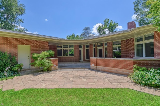 823 S Flood Ave, Norman, OK 73069 - rear view of house with a patio area, a chimney, and brick siding