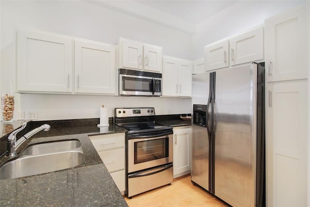 1 NE 2nd St Unit 402, Oklahoma City, OK 73104 - kitchen with stainless steel appliances, white cabinetry, dark stone counters, and light wood-style floors