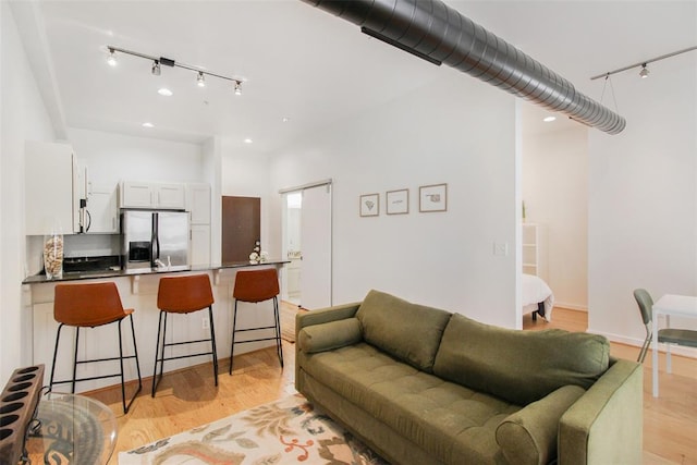 1 NE 2nd St Unit 402, Oklahoma City, OK 73104 - living room with rail lighting, light wood-style floors, and recessed lighting