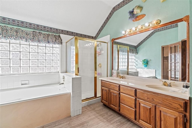 4924 Byron Cir, Yukon, OK 73099 - bathroom with lofted ceiling, a bath, double vanity, a stall shower, and wood finished floors