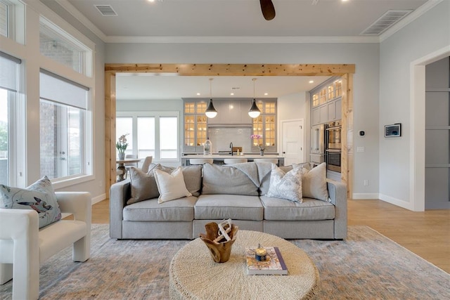 3624 Utica Square Dr, Edmond, OK 73034 - living area with light wood finished floors, crown molding, and a ceiling fan