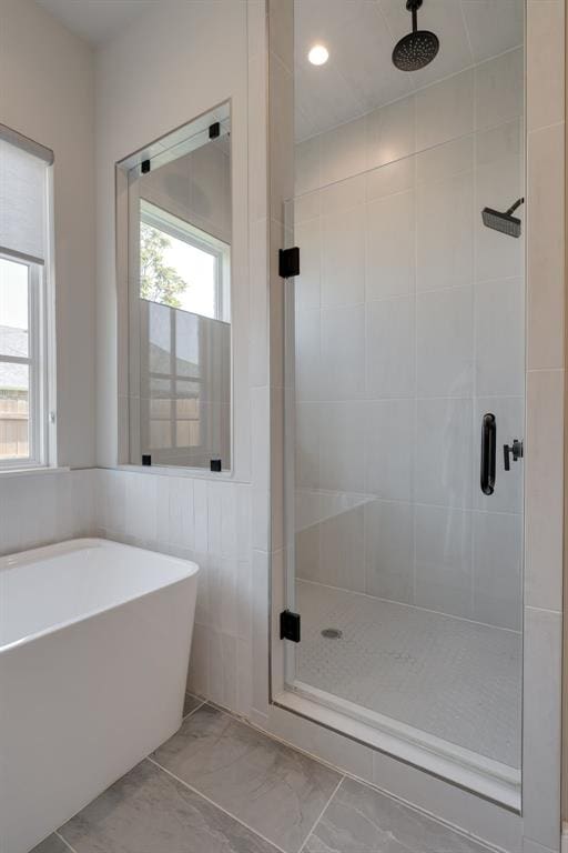 3624 Utica Square Dr, Edmond, OK 73034 - bathroom with a stall shower, marble look tiles, a freestanding bath, and recessed lighting