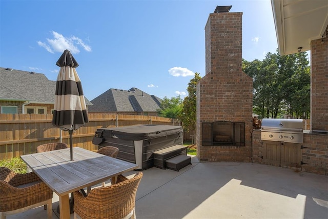 3624 Utica Square Dr, Edmond, OK 73034 - fenced backyard featuring an outdoor brick fireplace, a patio area, a hot tub, outdoor dining area, and an outdoor kitchen