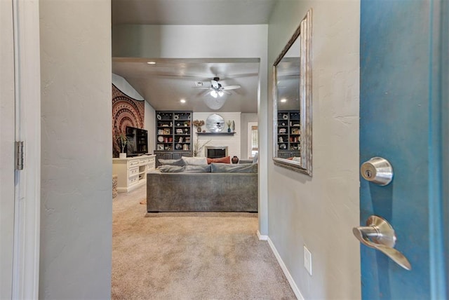 1229 S Gemini Rd, Edmond, OK 73003 - carpeted living area with a ceiling fan, a fireplace, and a textured wall