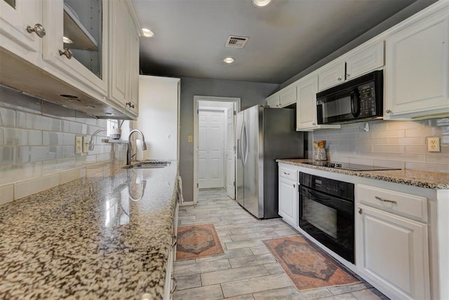 1229 S Gemini Rd, Edmond, OK 73003 - kitchen with black appliances, white cabinets, backsplash, recessed lighting, and light stone countertops