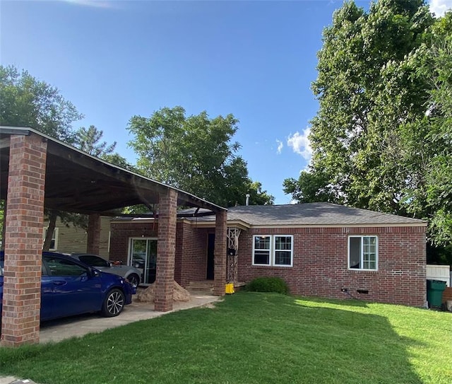 2451 NW 42nd St, Oklahoma City, OK 73112 - view of front of property with a front yard, crawl space, a carport, and brick siding
