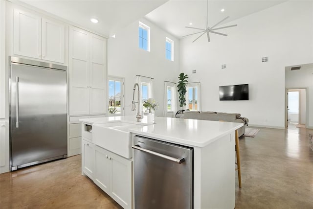1006 Dorsi Way, Newcastle, OK 73065 - kitchen with appliances with stainless steel finishes, finished concrete floors, open floor plan, a towering ceiling, and a kitchen island with sink