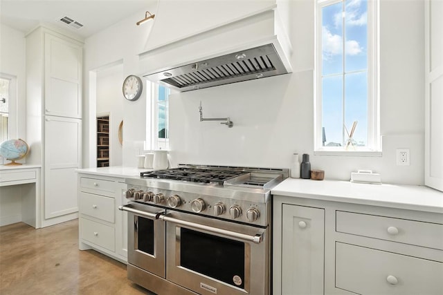 1006 Dorsi Way, Newcastle, OK 73065 - kitchen featuring range with two ovens, custom exhaust hood, light countertops, and healthy amount of natural light
