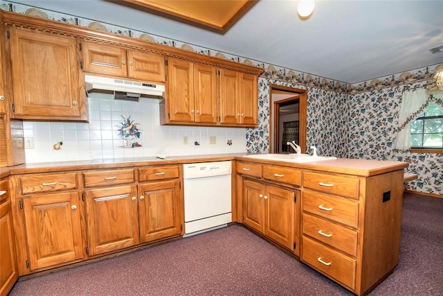 511 N Turner Rd, Chandler, OK 74834 - kitchen with white dishwasher, under cabinet range hood, wallpapered walls, a peninsula, and brown cabinetry