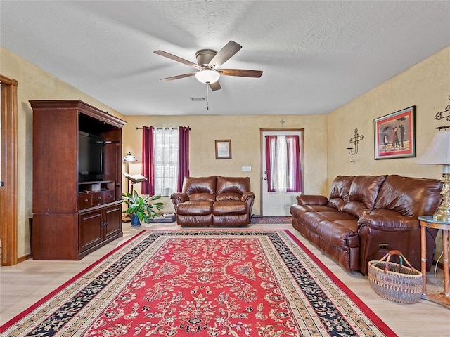 1008 County Road 1580, Marlow, OK 73055 - living room featuring plenty of natural light, a ceiling fan, light wood-type flooring, and a textured ceiling