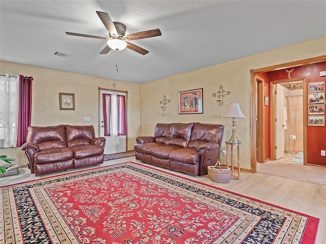 1008 County Road 1580, Marlow, OK 73055 - living room with a ceiling fan, wood finished floors, and a textured ceiling