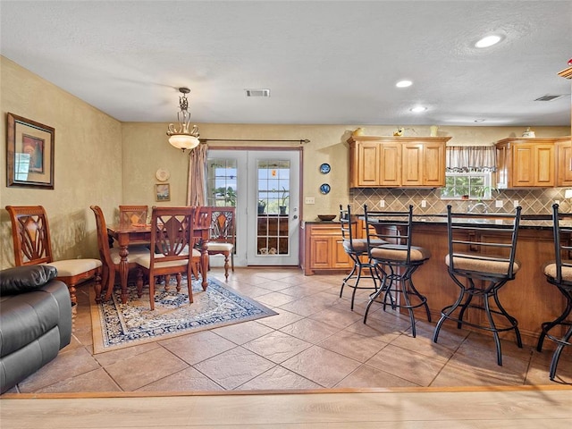 1008 County Road 1580, Marlow, OK 73055 - kitchen featuring a kitchen breakfast bar, backsplash, dark countertops, pendant lighting, and recessed lighting