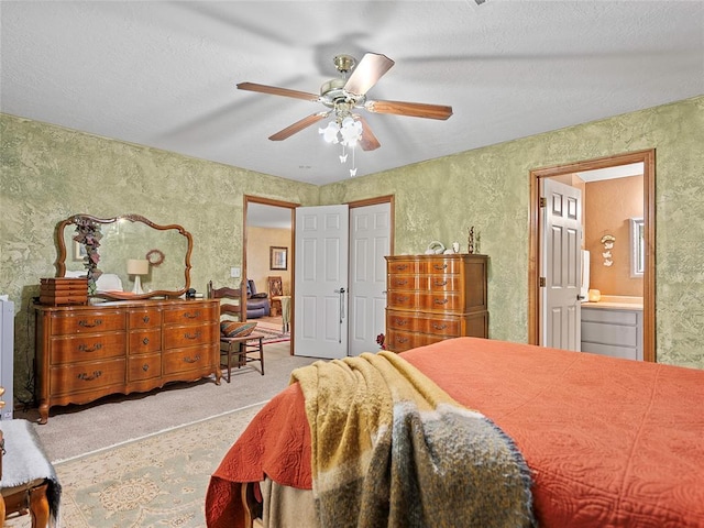 1008 County Road 1580, Marlow, OK 73055 - carpeted bedroom featuring ensuite bath, a ceiling fan, and a textured ceiling