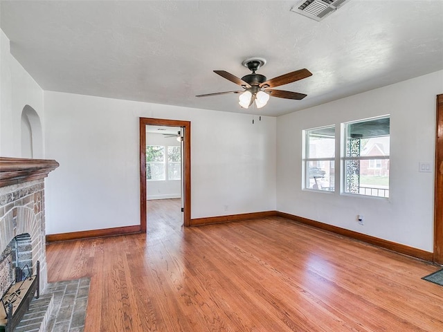 2212 N Kelham Ave, Oklahoma City, OK 73111 - unfurnished living room featuring a ceiling fan, a fireplace with raised hearth, and light wood finished floors