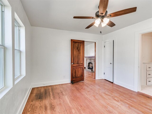 2212 N Kelham Ave, Oklahoma City, OK 73111 - unfurnished bedroom with light wood finished floors, a brick fireplace, and ceiling fan