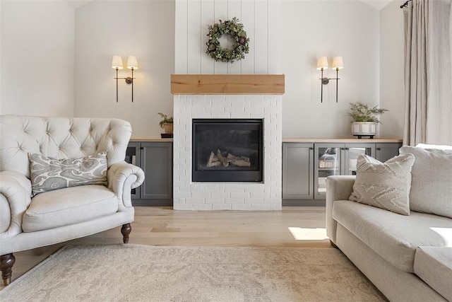 1724 Campus Corner Pl, Edmond, OK 73034 - living room featuring wood finished floors, lofted ceiling, and a brick fireplace