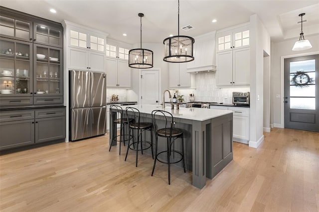 1724 Campus Corner Pl, Edmond, OK 73034 - kitchen featuring freestanding refrigerator, a breakfast bar area, backsplash, light wood-type flooring, and recessed lighting