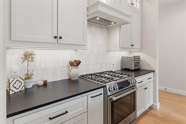 1724 Campus Corner Pl, Edmond, OK 73034 - kitchen with stainless steel gas stove, custom exhaust hood, white cabinetry, and dark countertops