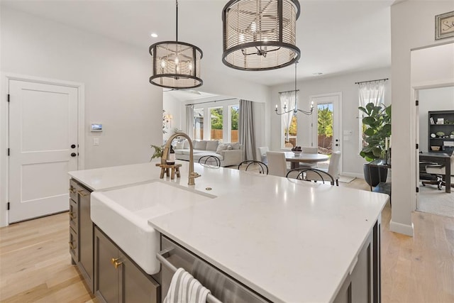 1724 Campus Corner Pl, Edmond, OK 73034 - kitchen featuring a chandelier, open floor plan, a center island with sink, light wood-style floors, and pendant lighting
