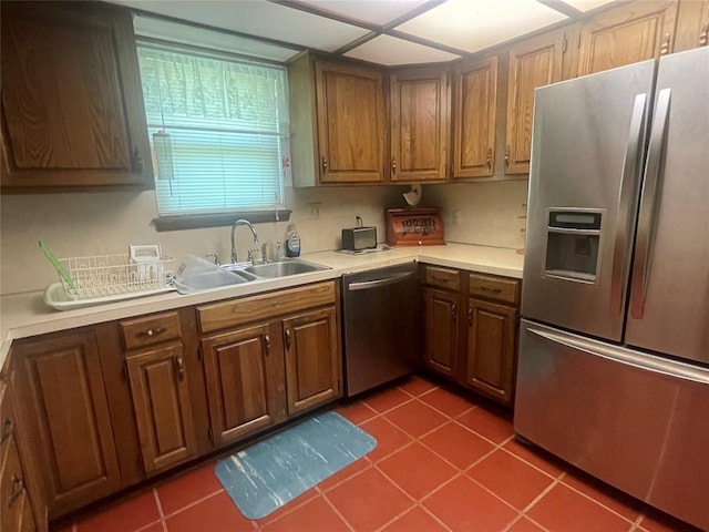 24400 Blackjack Rd, Perry, OK 73077 - kitchen featuring appliances with stainless steel finishes, light countertops, dark tile patterned flooring, and brown cabinets