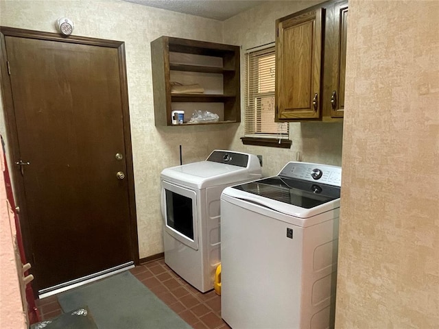 24400 Blackjack Rd, Perry, OK 73077 - laundry area with cabinet space, washing machine and dryer, a textured wall, and dark tile patterned flooring