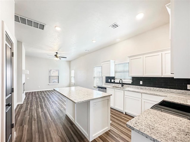 1101 N Tucker Ave, Shawnee, OK 74801 - kitchen with ceiling fan, backsplash, dark wood-style floors, a center island, and white cabinets