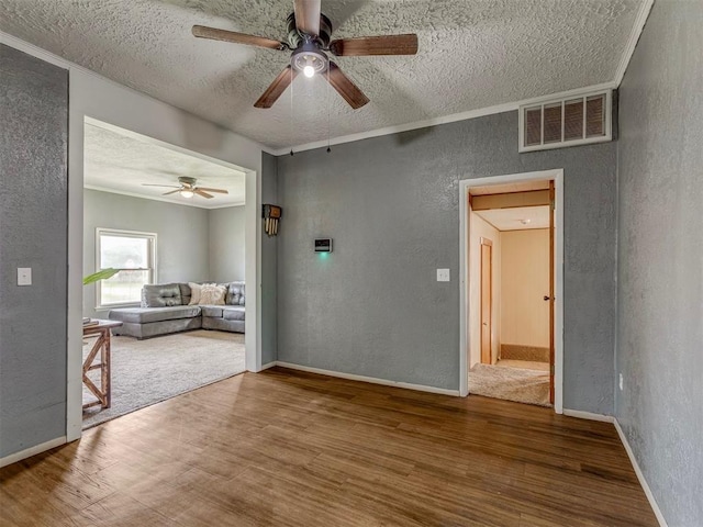 901 S 11th St, Kingfisher, OK 73750 - empty room with a textured wall, a textured ceiling, wood finished floors, and ceiling fan