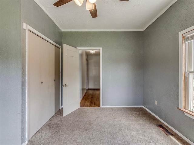 901 S 11th St, Kingfisher, OK 73750 - unfurnished bedroom featuring a textured wall, carpet floors, a closet, crown molding, and a textured ceiling