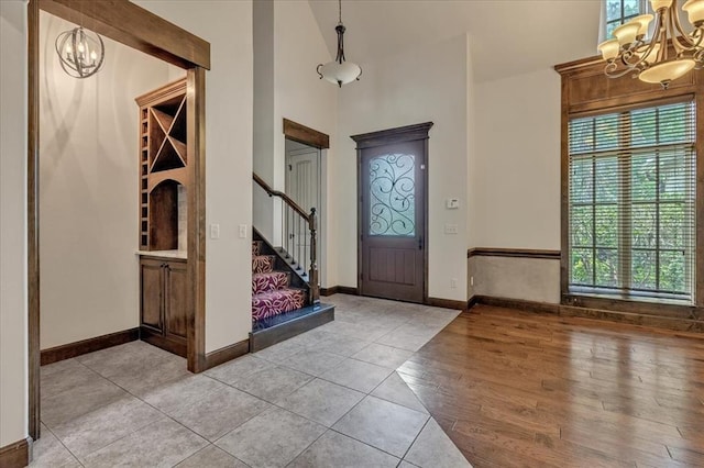 5000 Tower Bridge Court, Edmond, OK 73034 - entryway with a chandelier, plenty of natural light, stairs, light tile patterned floors, and a towering ceiling