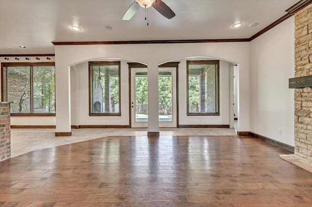 5000 Tower Bridge Court, Edmond, OK 73034 - unfurnished living room featuring ornamental molding, hardwood / wood-style flooring, ceiling fan, and arched walkways