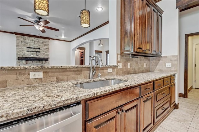 5000 Tower Bridge Court, Edmond, OK 73034 - kitchen with stainless steel dishwasher, a ceiling fan, ornamental molding, light stone countertops, and arched walkways