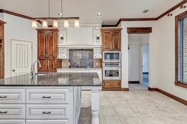 5000 Tower Bridge Court, Edmond, OK 73034 - kitchen featuring appliances with stainless steel finishes, ornamental molding, tasteful backsplash, dark stone counters, and light tile patterned floors