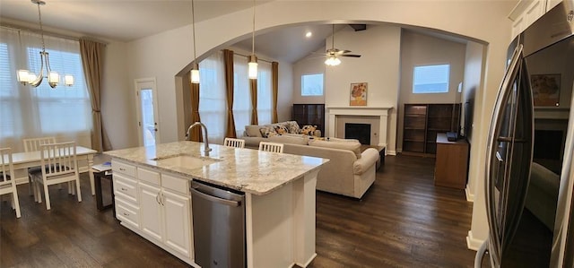 821 Mount Irving Way, Norman, OK 73071 - kitchen with stainless steel appliances, arched walkways, light stone counters, dark wood-style floors, and vaulted ceiling
