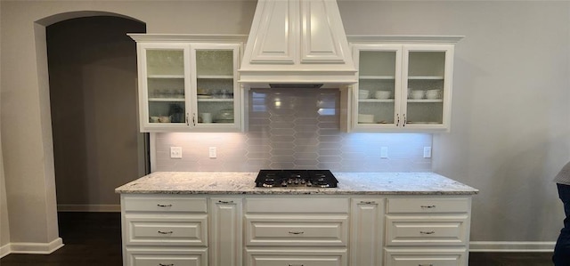 821 Mount Irving Way, Norman, OK 73071 - kitchen featuring stainless steel gas stovetop, backsplash, arched walkways, custom exhaust hood, and light stone countertops