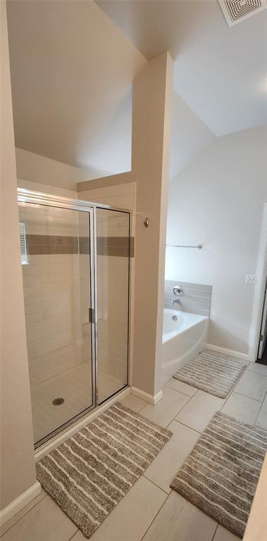 821 Mount Irving Way, Norman, OK 73071 - full bath with vaulted ceiling, a garden tub, a shower stall, and tile patterned flooring